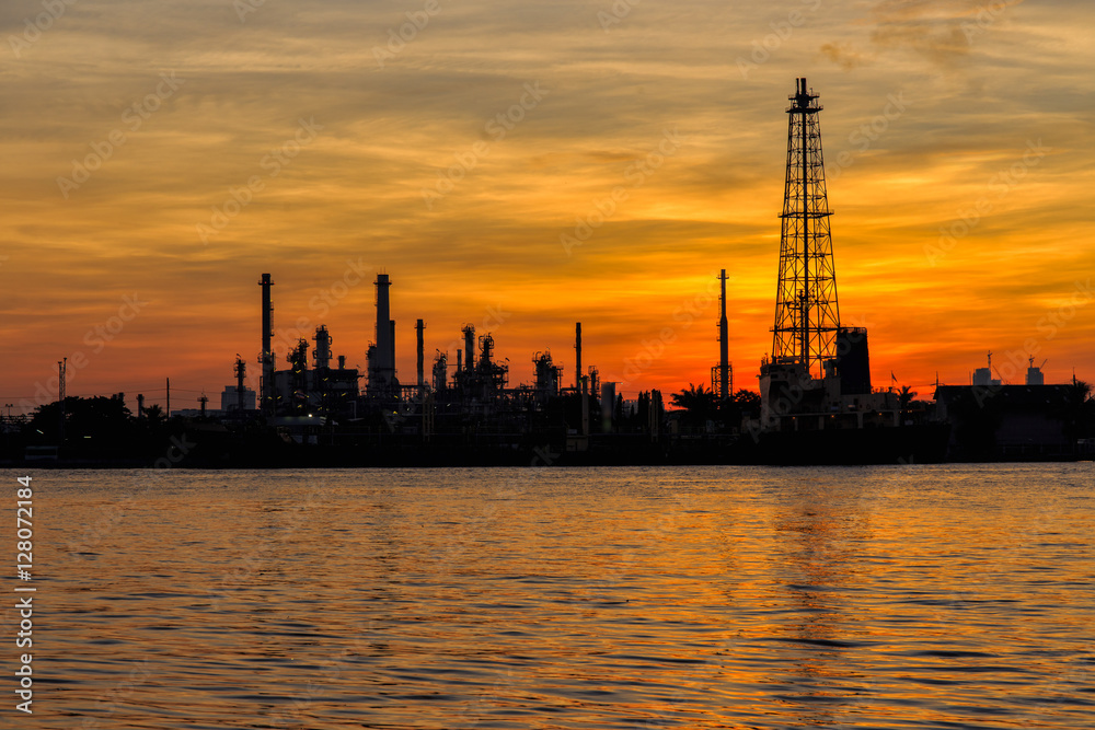 Oil refinery silhouette along the river at sunrise time Oil refinery silhouette along the river at sunrise time