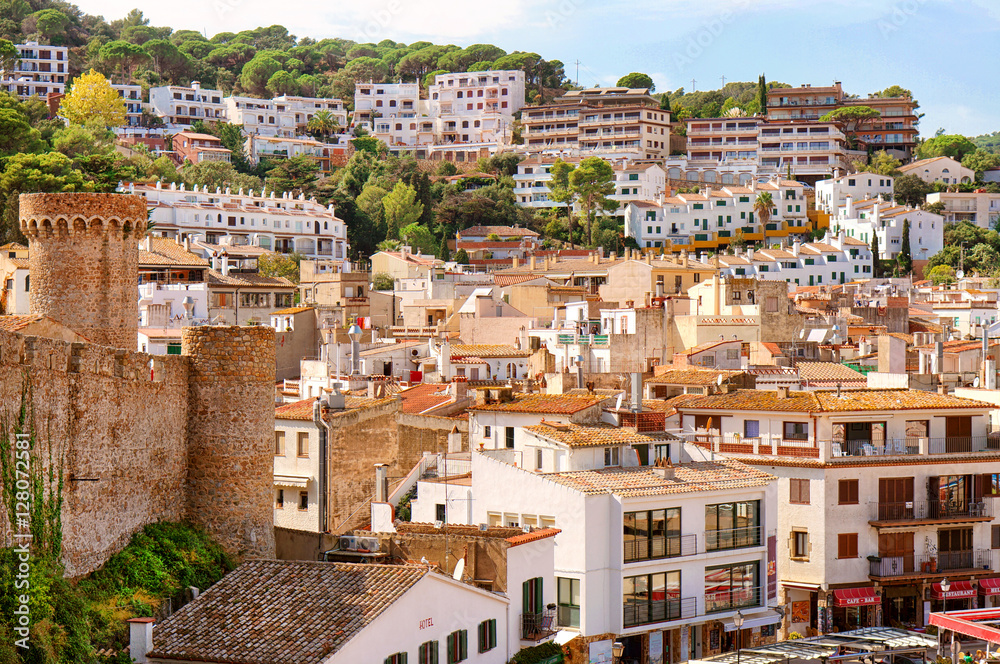 Aerial view of European town on a natural hills with many bars, hotels and restaurants in sunny day with blue sky. Tossa De Mar, Costa Brava, Spain.