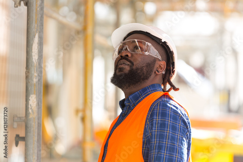 African american engineer looking upwards among scaffolding