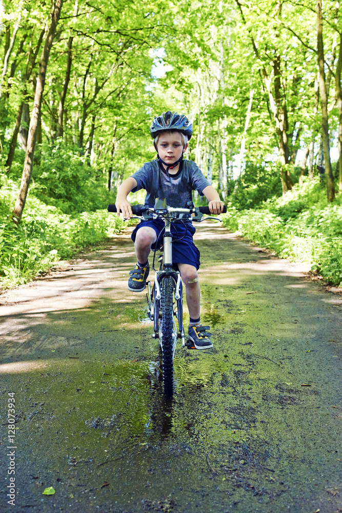 Fototapeta premium Young boy riding bicycle on a summer day