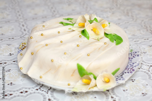 White mastic cake decorated with flowers, closeup