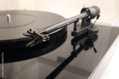 Tone arm of a modern high quality turntable record player for vinyl analogue music in shallow focus.