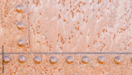 A grunge rusty metal background with rivits and welds dividing i