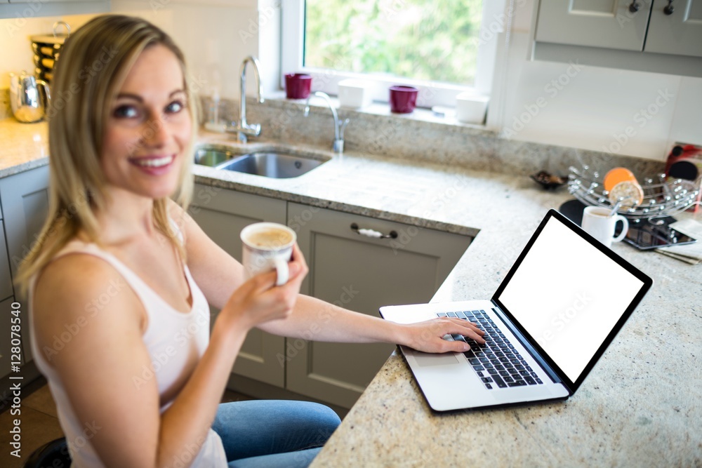 Pretty blonde woman having coffee and using laptop Pretty blonde woman having coffee and using laptop