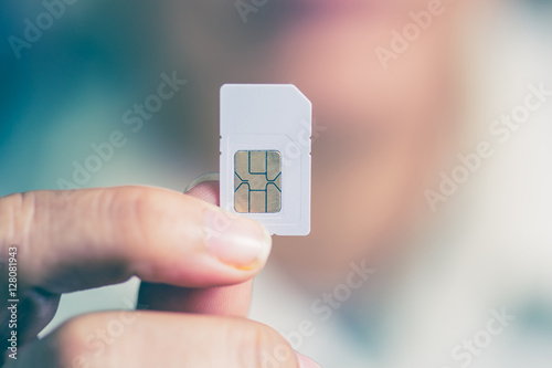 Hand holding sim card, select focus, color effect photo