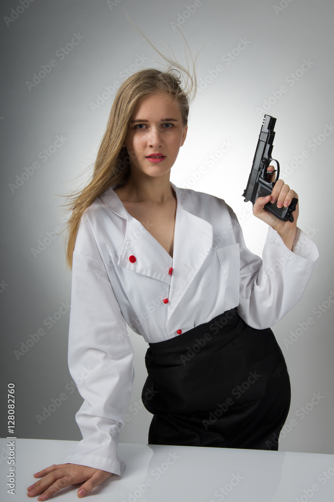 Serious Caucasian young woman with long black hair in intimate / with a gun Serious Caucasian young woman with long black hair in intimate / with a gun