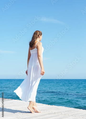 Woman in a white dress on a wooden pier
