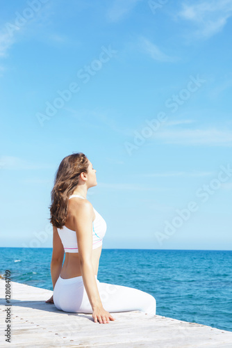 Woman in white sporty clothes next to the sea © Acronym