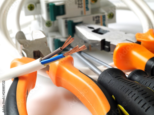 stripped wire in front of electric tools and equipment, shallow depth of field