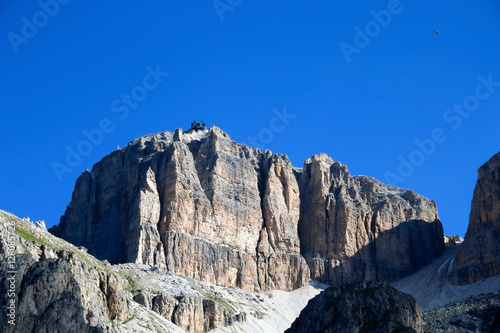 Sass Pordoi mountain massif with cable car leading on top with blue sky background, Dolomites, Italy