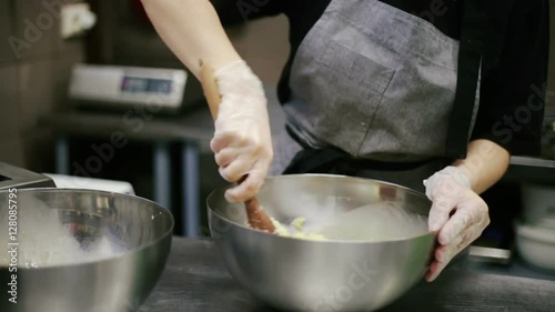 Confectioner stir cookie dough in a bowl.
