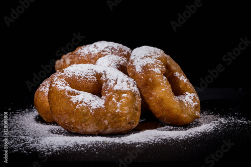 Sprinkling sugar powder on donut