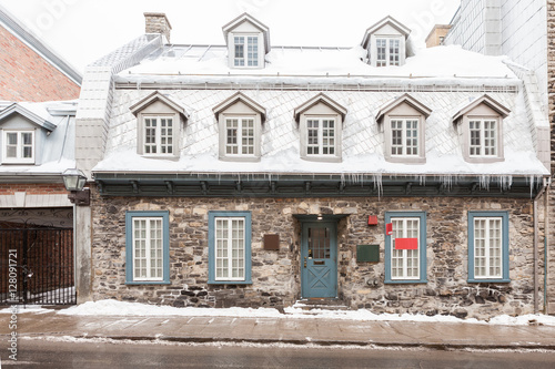 Stone house covered with snow and ice in winter in a Canadian ci