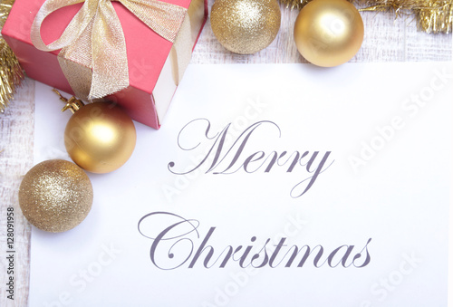 Text merry christmas on paper with balls and gift box
