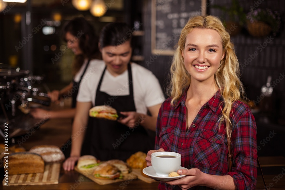 Smiling blonde customer in front of the counter