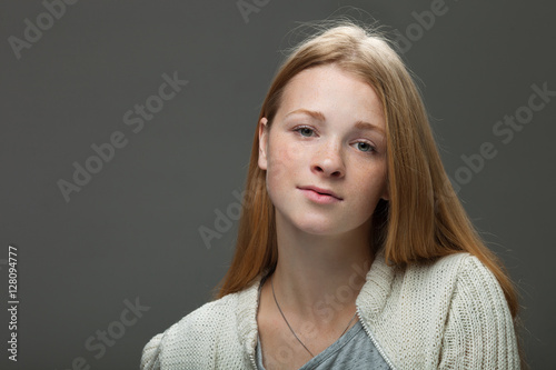 Human face expressions and emotions. Portrait of young adorable redhead woman in cozy shirt looking looking cute and thoughtfully.