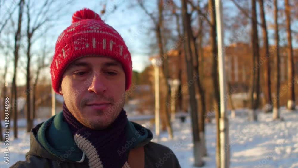Pensive man in red hat walking in winter park 4K stabilized snorricam shot Pensive man in red hat walking in winter park 4K stabilized snorricam shot