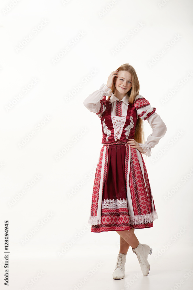 Young beautiful redhead folk dancer woman with gorgeous long hair in traditional authentic folk costume posing isolated on white background Young beautiful redhead folk dancer woman with gorgeous long hair in traditional authentic folk costume posing isolated on white background