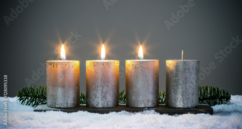 Dritte Advent - Vier silberne Adventskerzen mit drei angezündeten Kerzen © diamant24