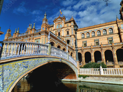 Gorgeous decorated bridge and stunning architecture against vivid blue sky at Plaza de Espana of Seville, Spain 