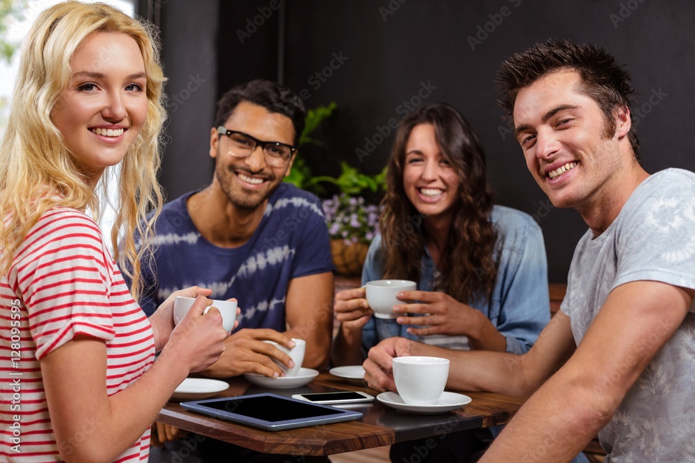 Obraz premium Smiling friends enjoying coffee together