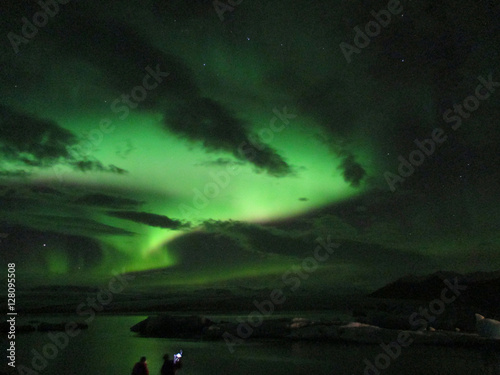 Admiring the awesome northern lights dancing over Jokulsarlon Glacier Lagoon, the southern part of Iceland 