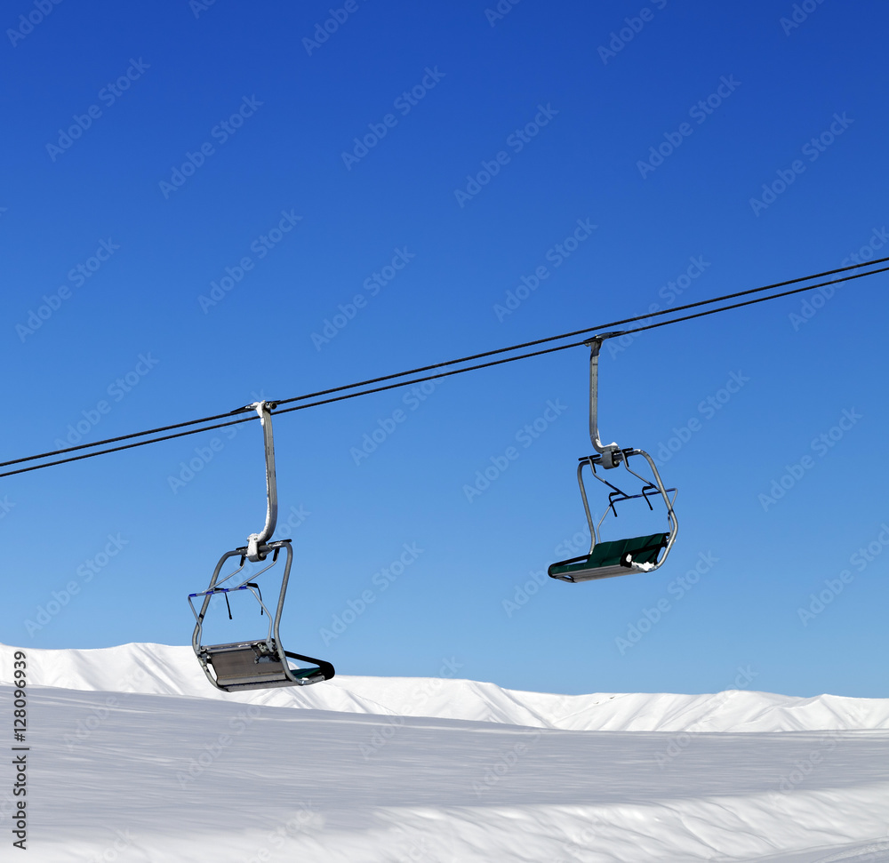 Chair-lift and blue clear sky at sun day Chair-lift and blue clear sky at sun day