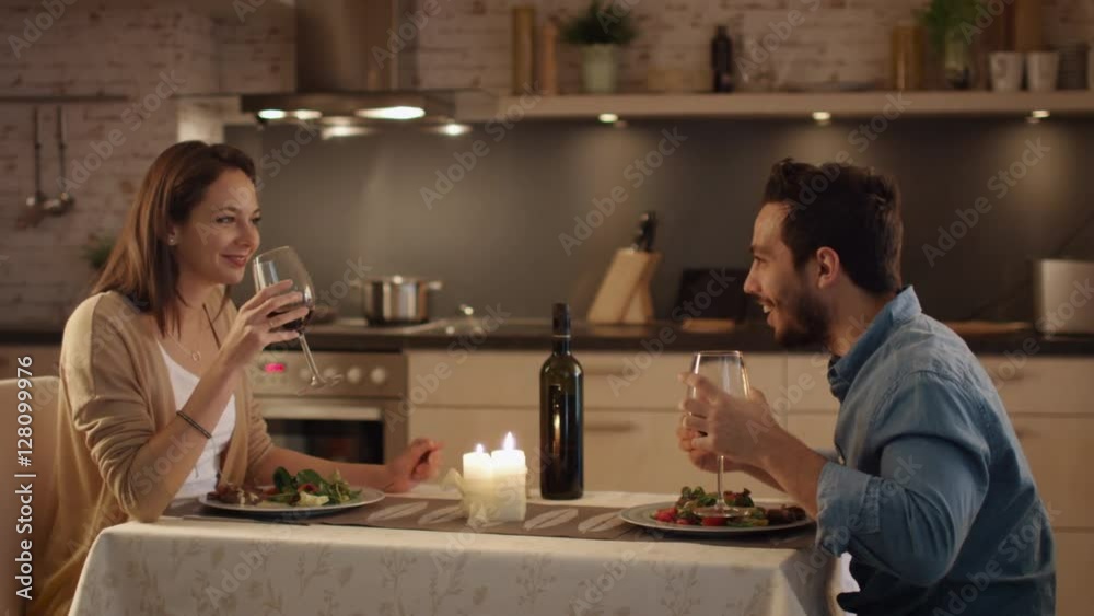 Beautiful Couple Having Candlelight Dinner in the Kitchen. They Drink Wine, Eat and Talk. Both are in Good Mood and Smile a lot. Shot on RED Cinema Camera in 4K (UHD). Beautiful Couple Having Candlelight Dinner in the Kitchen. They Drink Wine, Eat and Talk. Both are in Good Mood and Smile a lot. Shot on RED Cinema Camera in 4K (UHD).