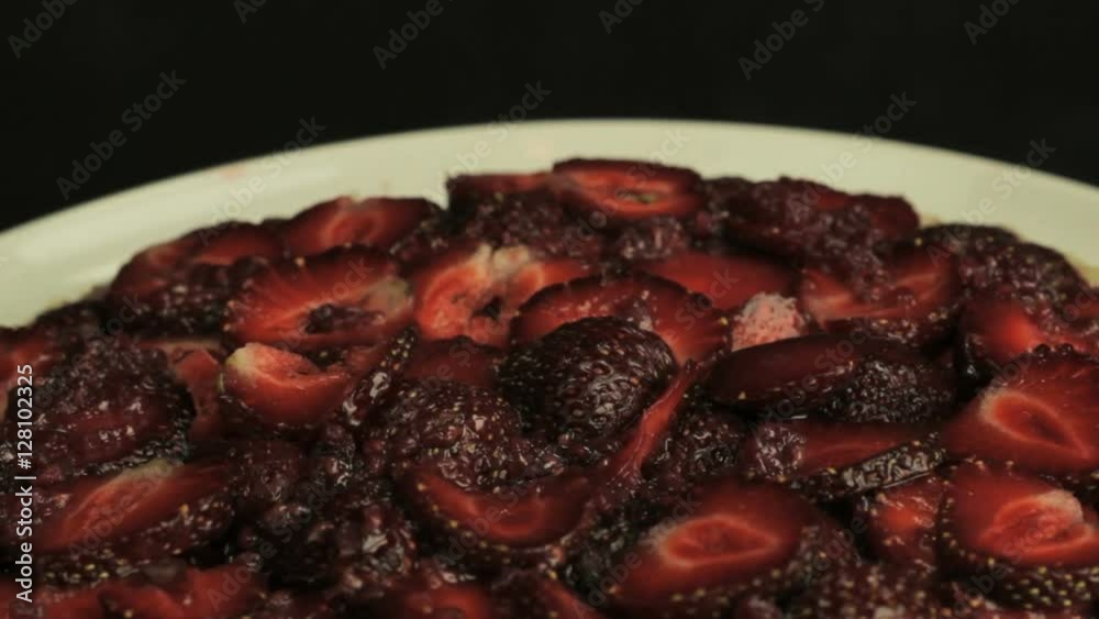 Red sliced strawberries in raspberry jam, rotates counterclockwise Red sliced strawberries in raspberry jam, rotates counterclockwise