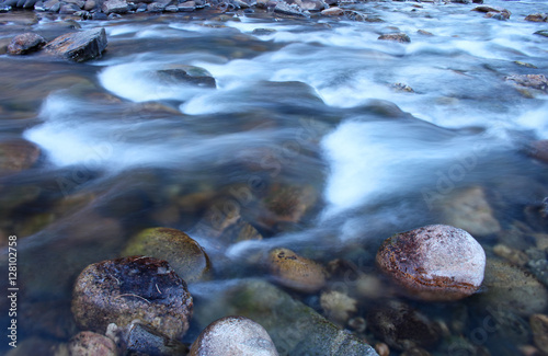 Icy water flows over rocks in the Poudre River in Colorado
