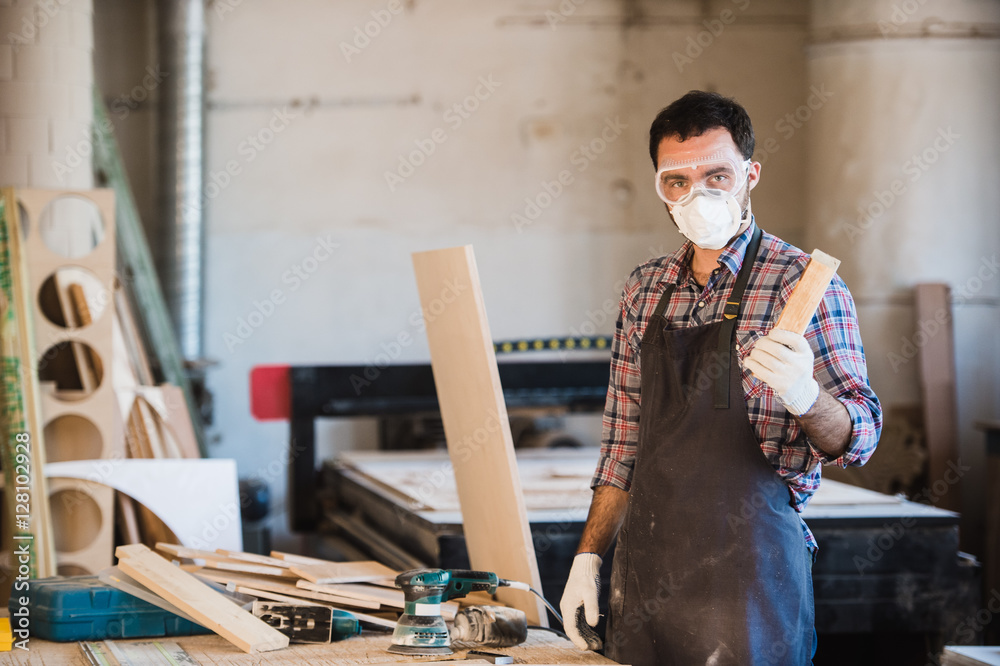 Horizontal view of professionally dressed carpenter varnishing a board Horizontal view of professionally dressed carpenter varnishing a board