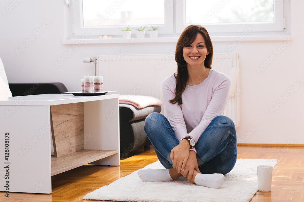Girl moving in a new apartment, sitting on the floor, looking ha Girl moving in a new apartment, sitting on the floor, looking ha