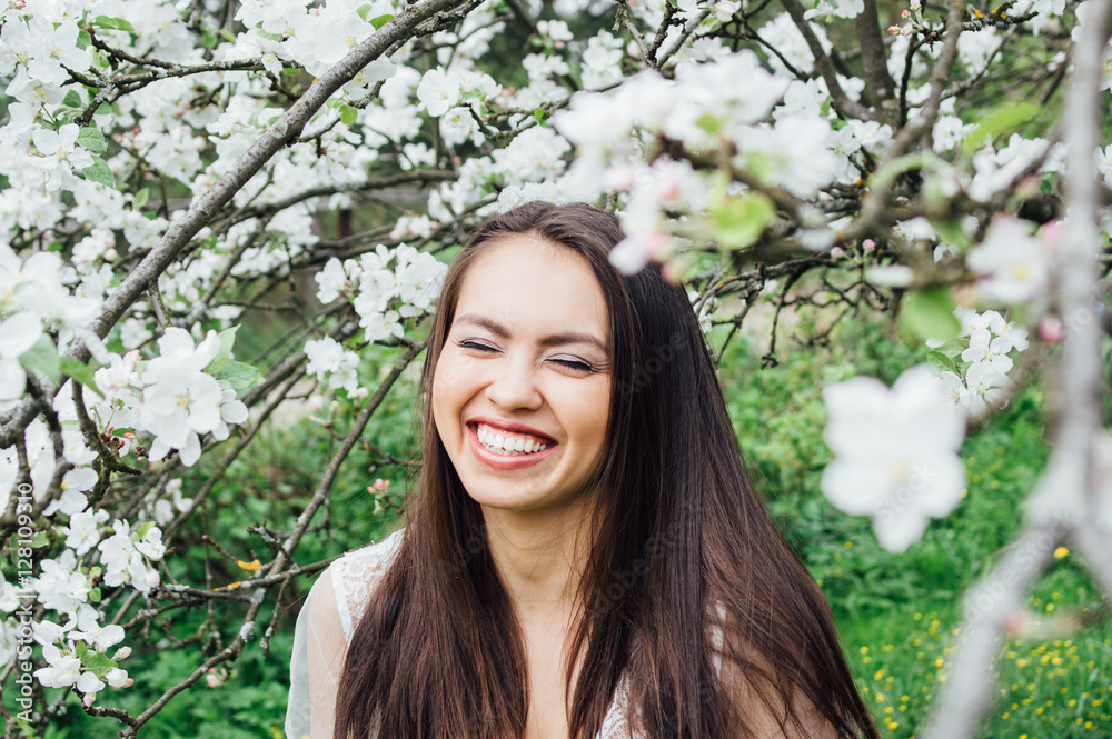 Portrait of laughing young girl in white dress in blossom apple garden, closed eyes Portrait of laughing young girl in white dress in blossom apple garden, closed eyes