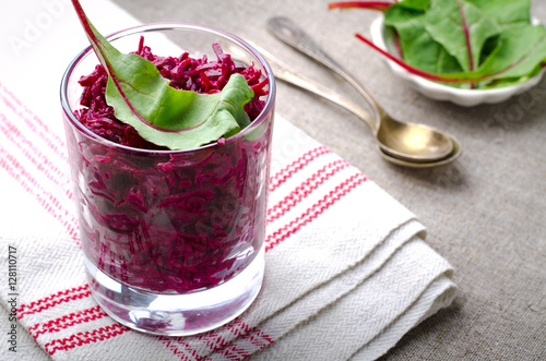 Fresh beet salad with chard leaves in glasses on linen gray background