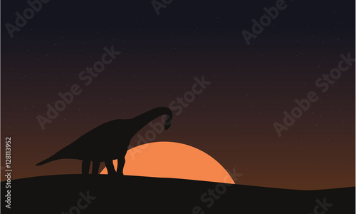 Silhouette of brachiosaurus on hill scenery