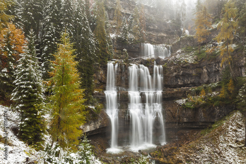 Vallesinella waterfall surrounded with snow covered pines, Trento, Italy photo