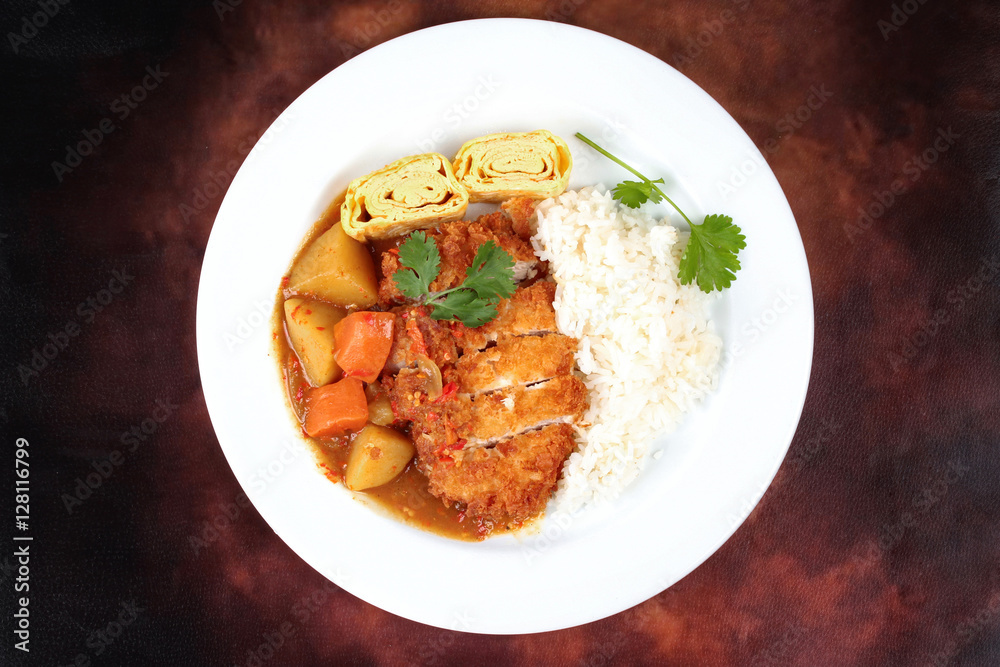 Rice with fried pork,omelet roll topped Japanese yellow curry . Rice with fried pork,omelet roll topped Japanese yellow curry .