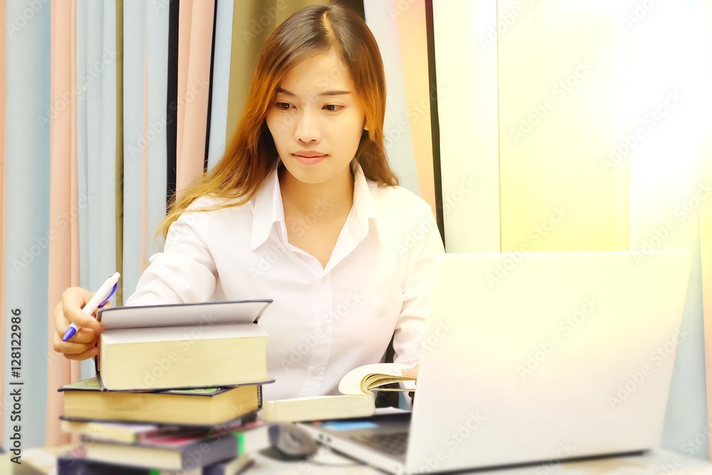 Business and Education Concept : Women are researching in libraries. Women are researching information for business. Artificial lighting techniques Business and Education Concept : Women are researching in libraries. Women are researching information for business. Artificial lighting techniques