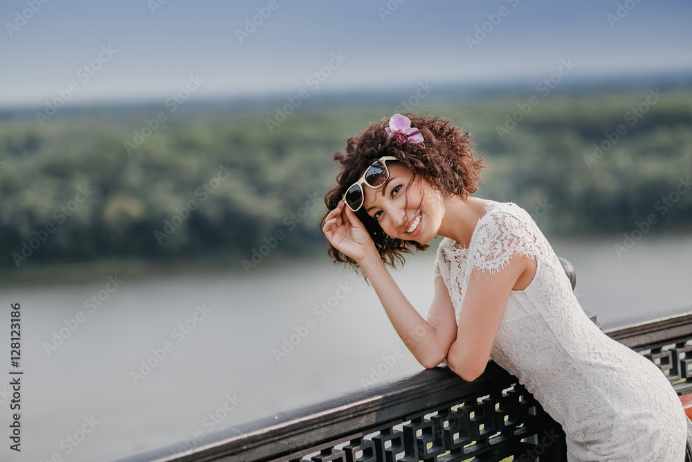 Outdoor portrait of beautiful happy mixed race young woman smiling with sunglasses