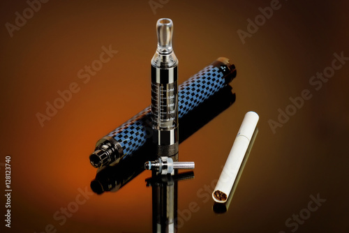 Vape, electronic cigarette exploded next to a conventional cigarette on a dark background with a gradient.