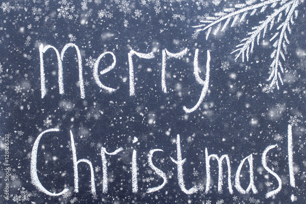Merry Christmas hand writing chalk text on black chalkboard Merry Christmas hand writing chalk text on black chalkboard