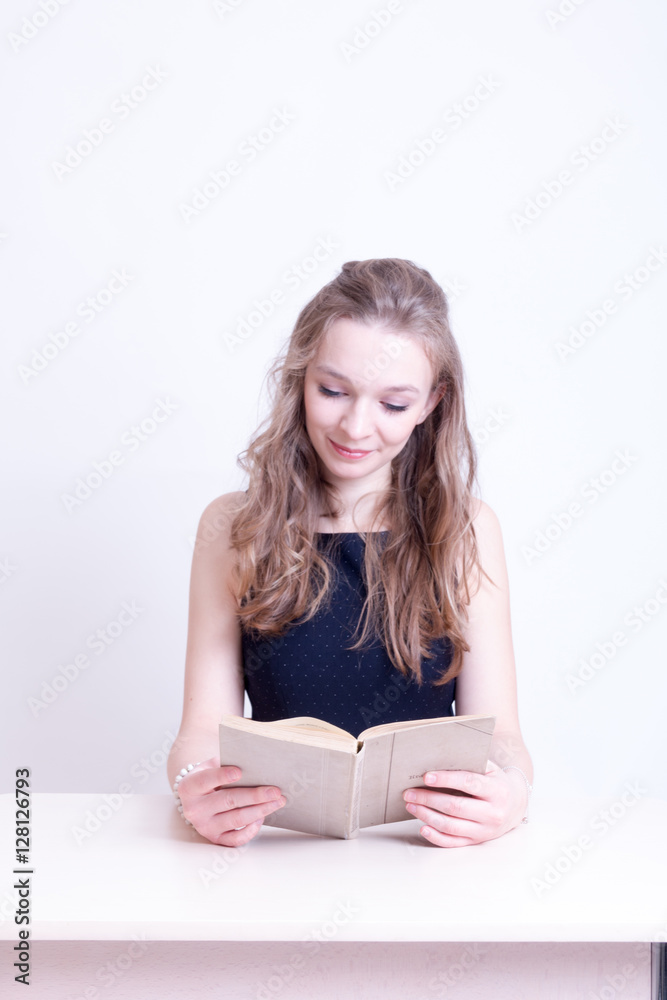 Mädchen beim Buch lesen am Tisch Mädchen beim Buch lesen am Tisch