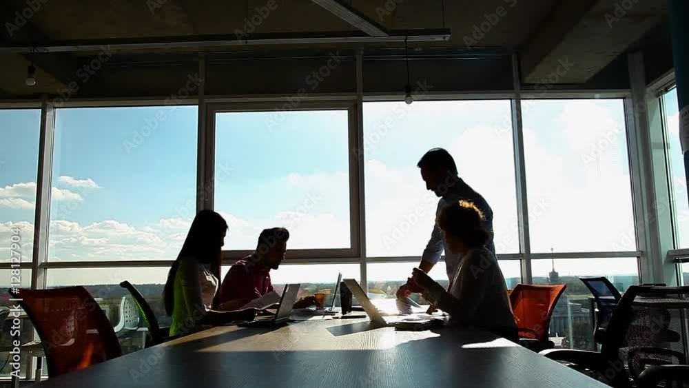 Business people working in board room, looking through documents and discussing business questions or issues while sitting in board room in office.