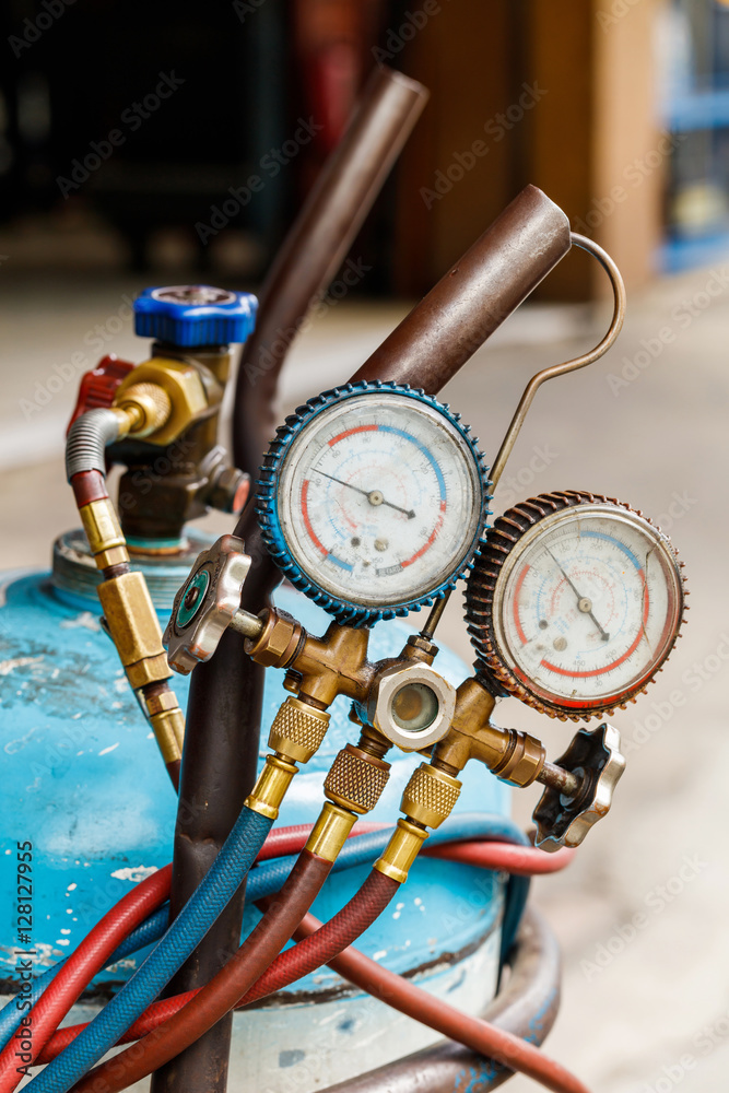 Fototapeta premium Refrigerant gas cylinder with manifold gauge