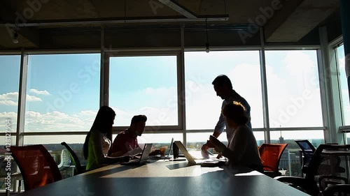 Business people working in board room, looking through documents and discussing business questions or issues while sitting in board room in office.