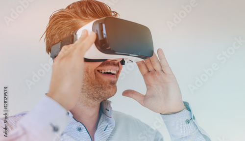 Smiling businessman using virtual reality headset