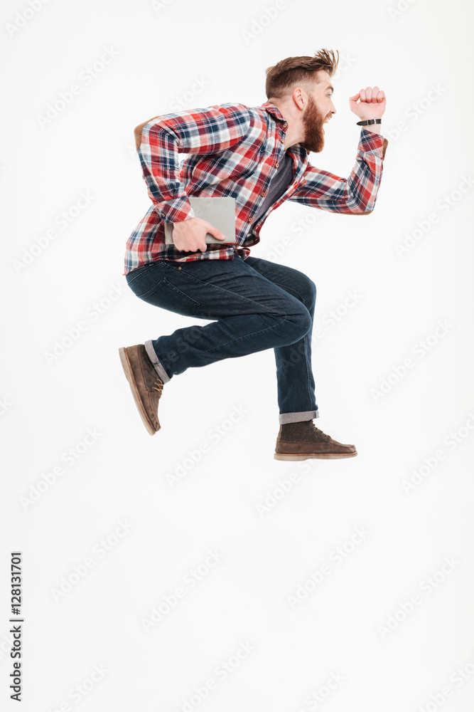 Naklejka premium Side view of a casual guy in plaid shirt jumping