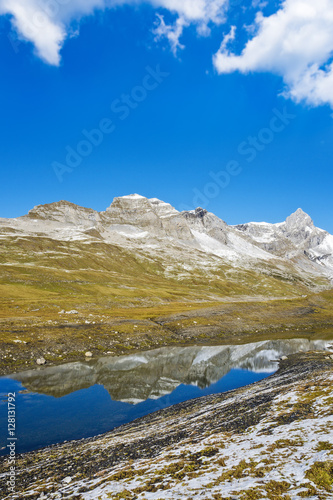 Blue mountain lake within snow capped peaks, Swiss Alps