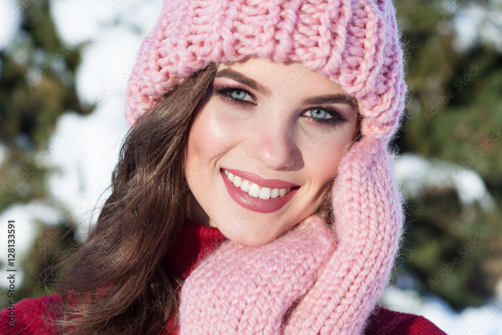 close up Winter portrait of a young smiling woman in a pink hat close up Winter portrait of a young smiling woman in a pink hat