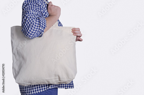 Mock-up. Girl is holding blank cotton tote bag isolated on white